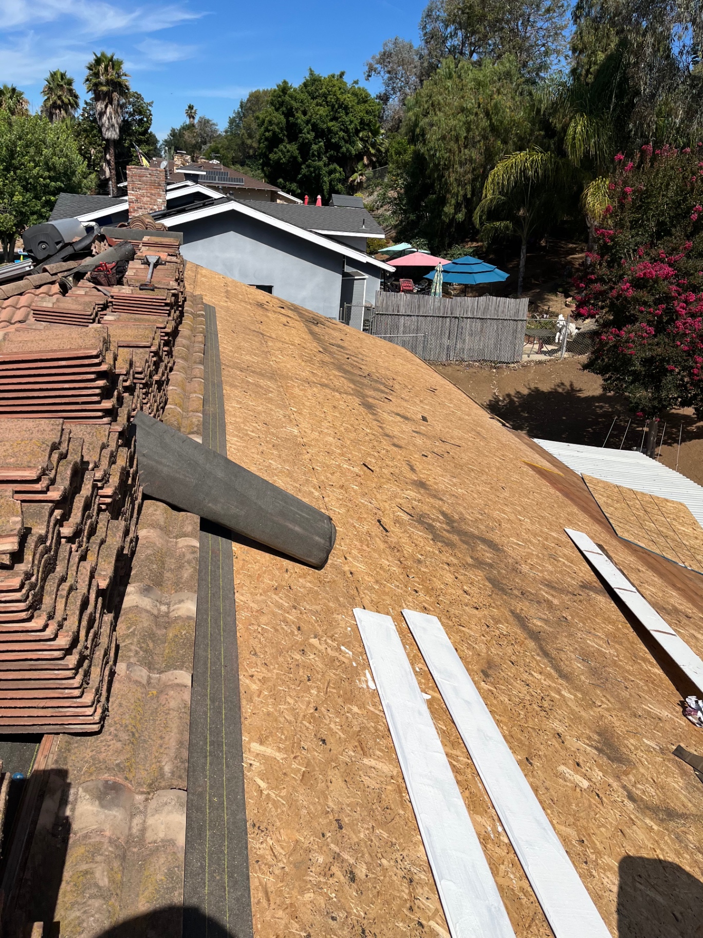 Spanish tile roof mid tear-off with fresh OSB decking installed in Los Angeles