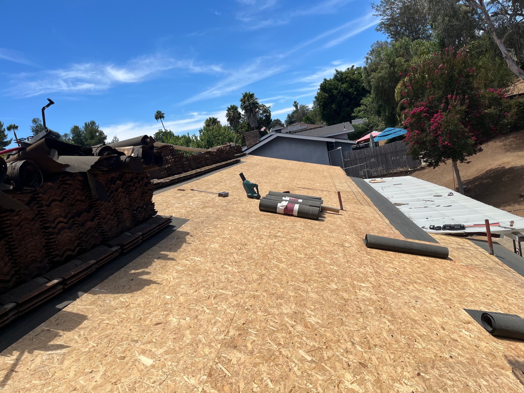 Roof decking installed and prepped with tile stacked and torch equipment ready