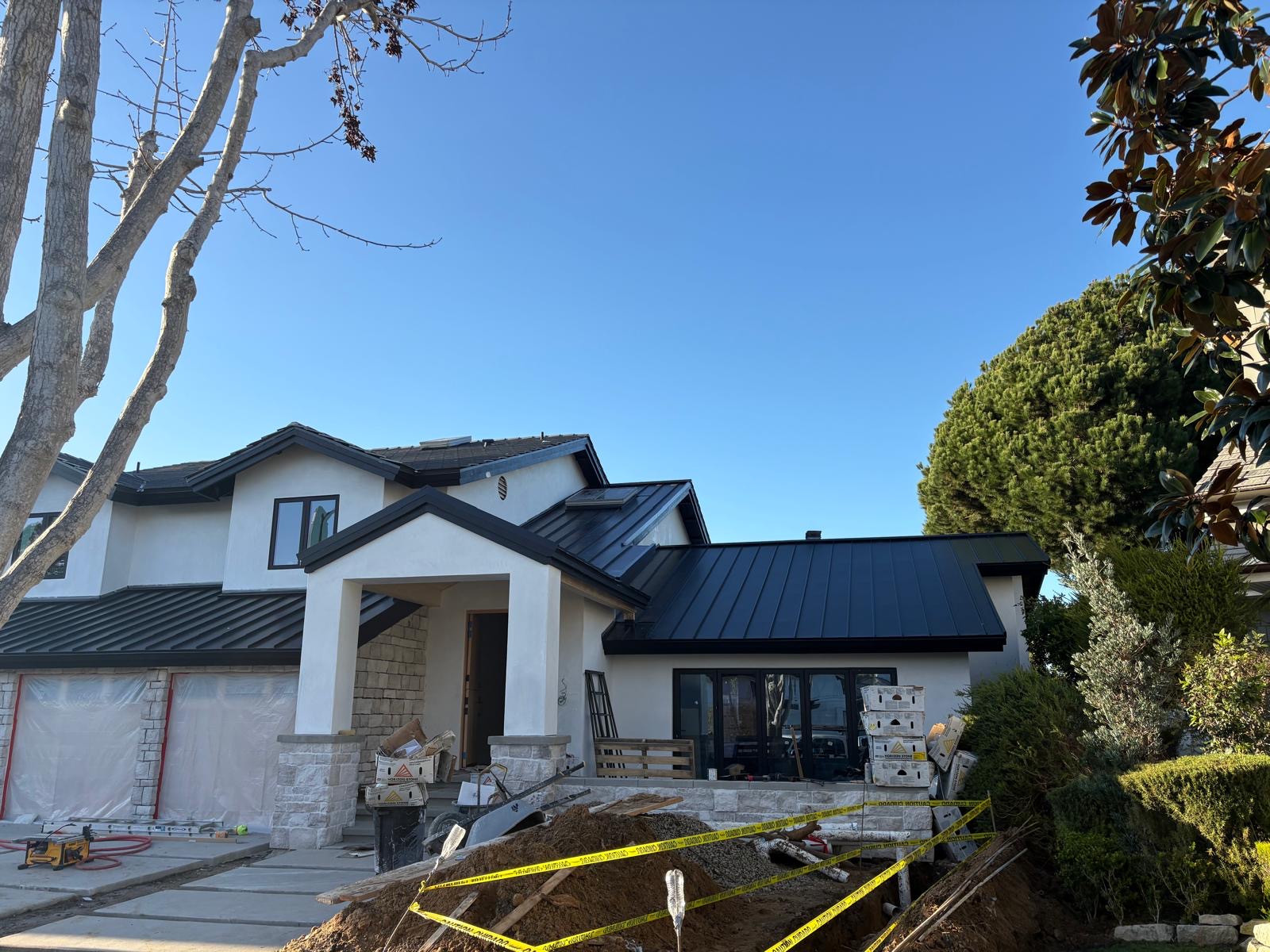 Front elevation of a Los Angeles home re-roofed in black standing seam metal and tile