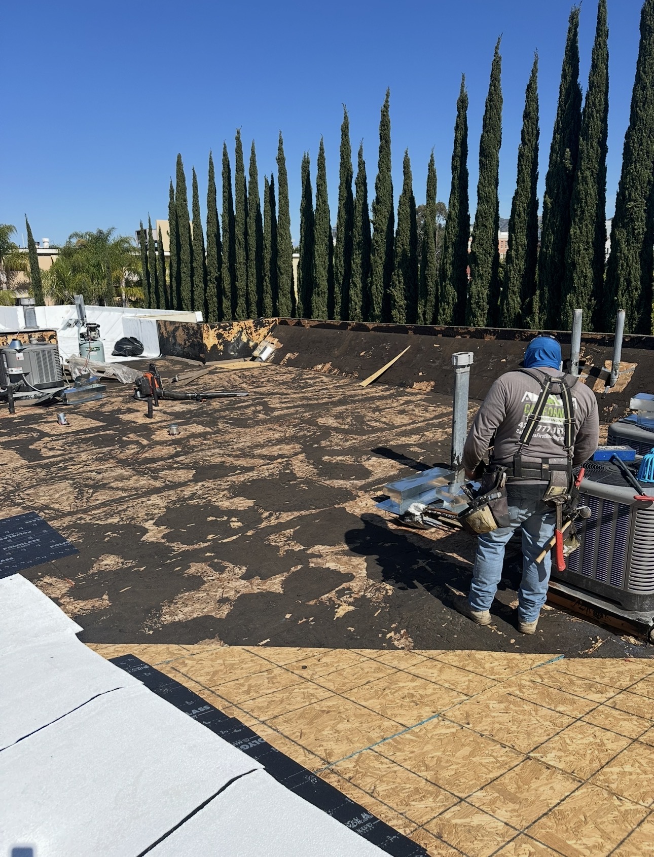 California First Roofing crew member on a flat roof after complete tear-off