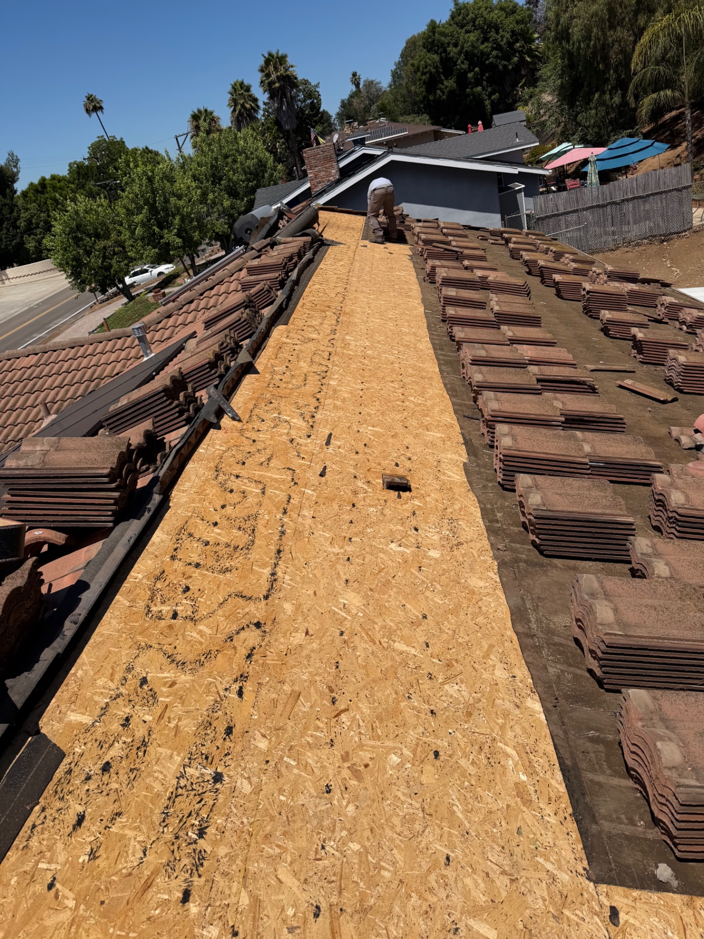 Roofer installing clay tile on a hillside Los Angeles home