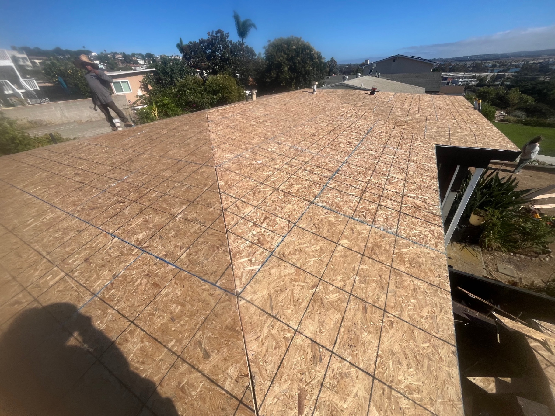 Freshly installed OSB roof decking with chalk lines ready for underlayment