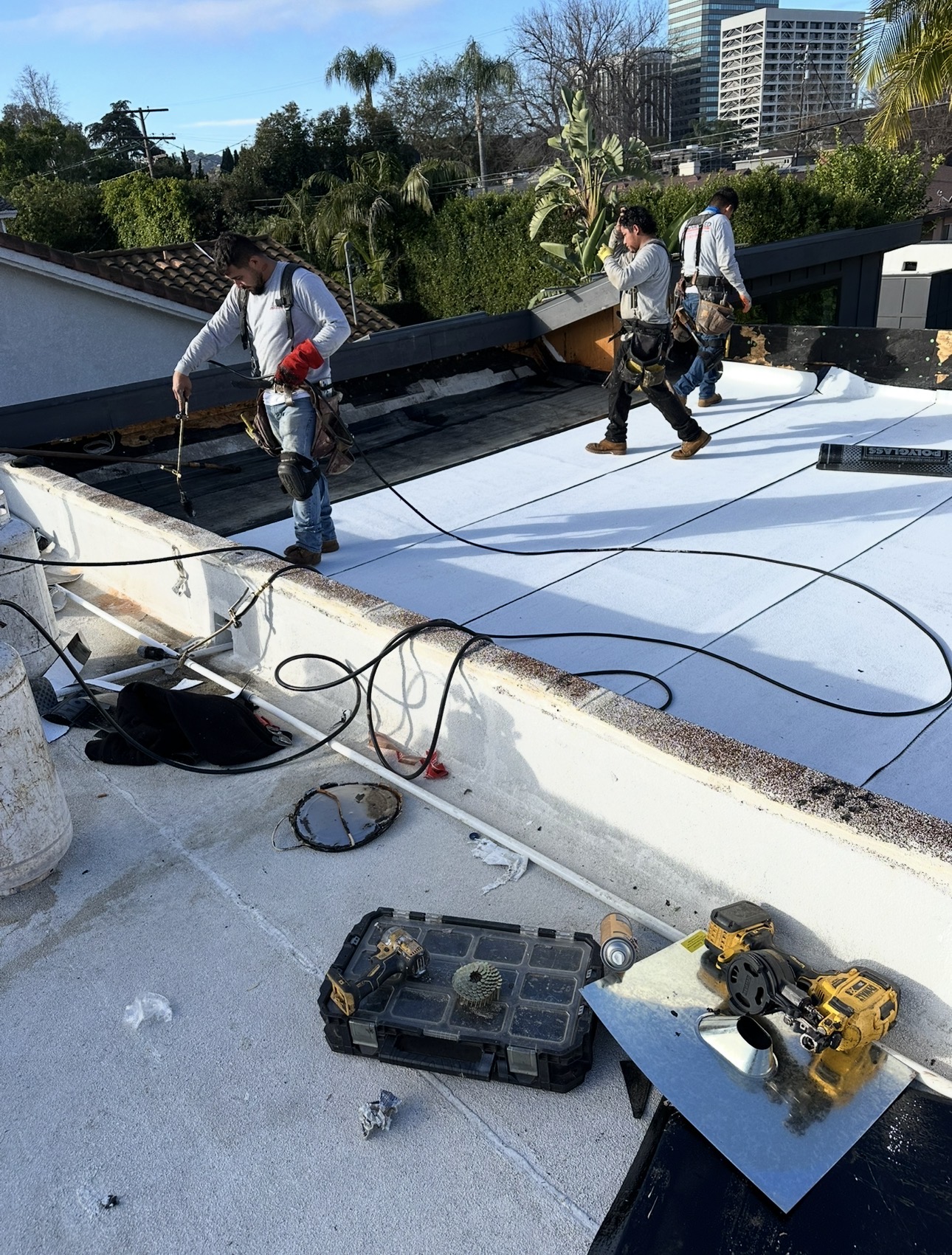 Three-man crew torching down cap sheet on a Westside LA flat roof