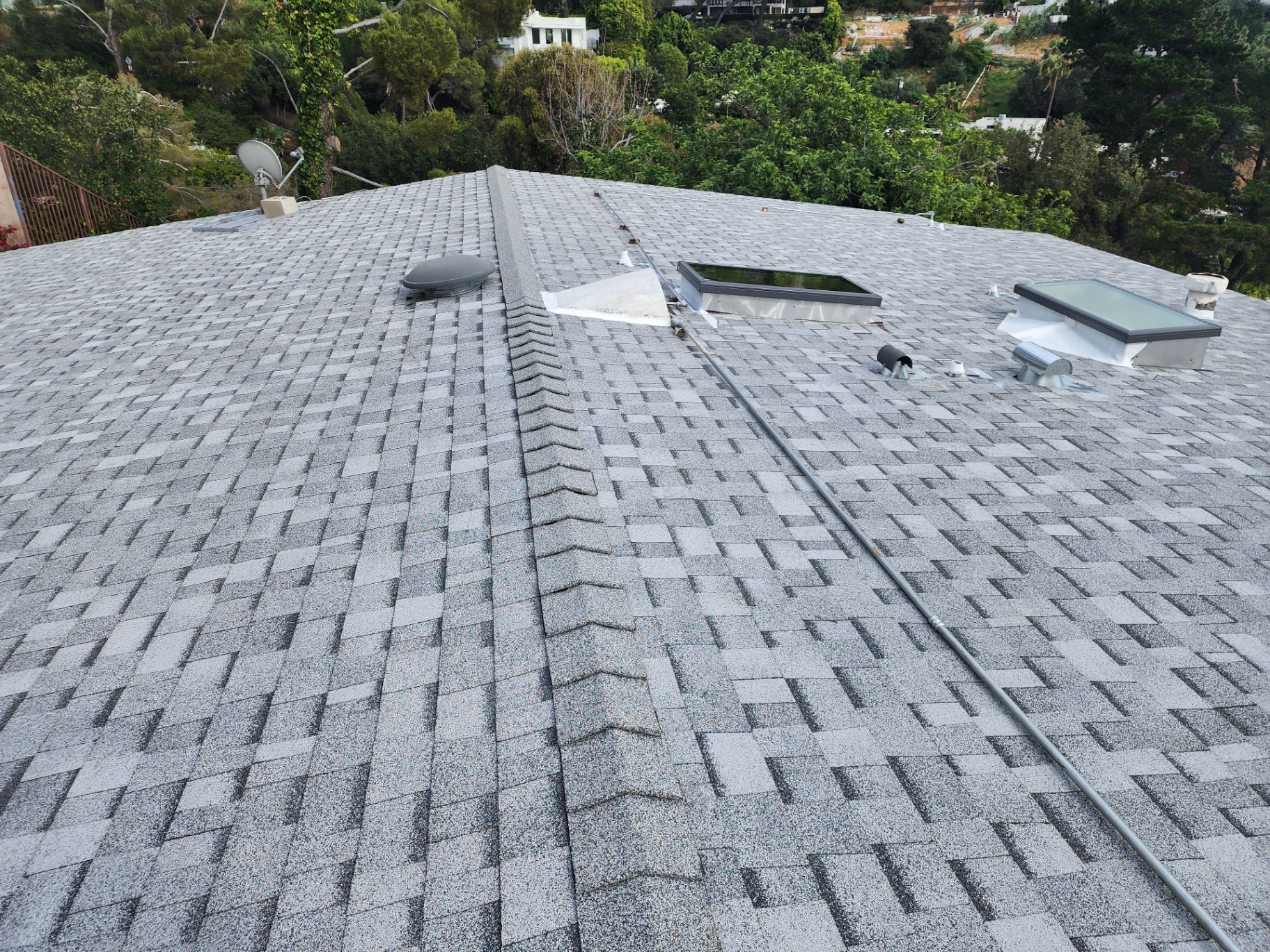 Fresh architectural shingle roof with clean ridge cap and skylights